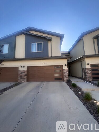 A modern house with a brown garage door is for sale.