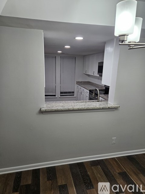 A kitchen with white cabinets and a window seat.