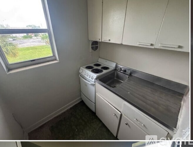 A small kitchen with a washing machine and a window.