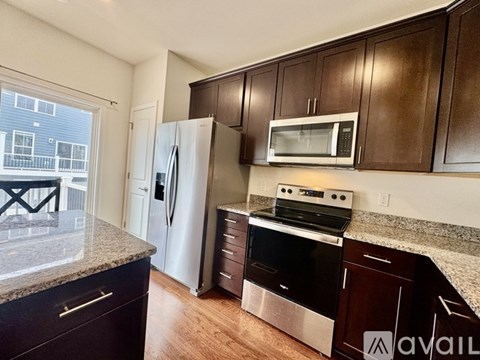A kitchen with brown cabinets and stainless steel appliances.