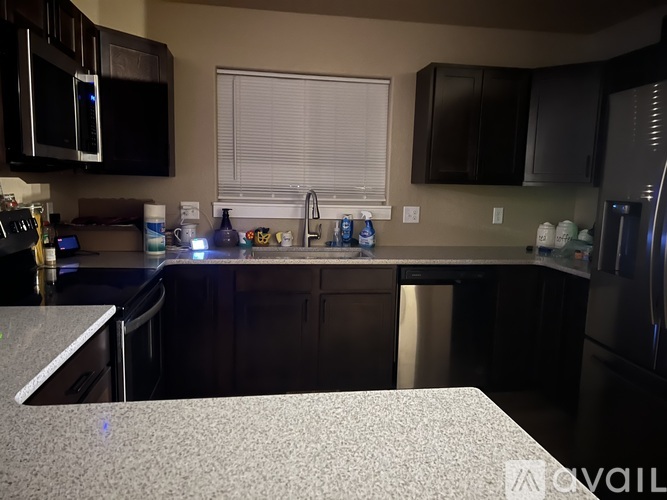 A kitchen with black cabinets and a granite countertop.