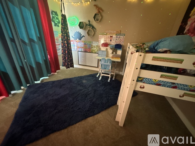 A child's bedroom with a white bunk bed and a blue rug.