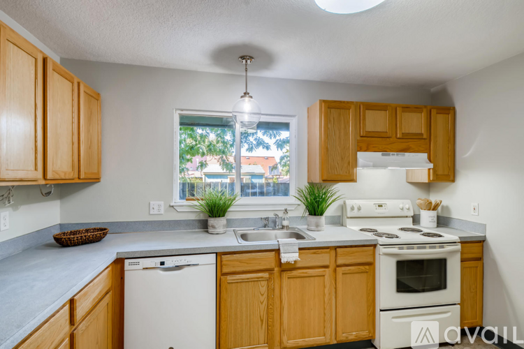 A kitchen with wooden cabinets and a white dishwasher.