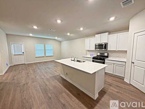 A spacious kitchen with white cabinets and a central island.