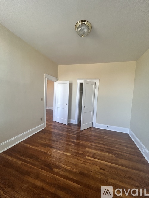 A room with wooden floors and two doors.