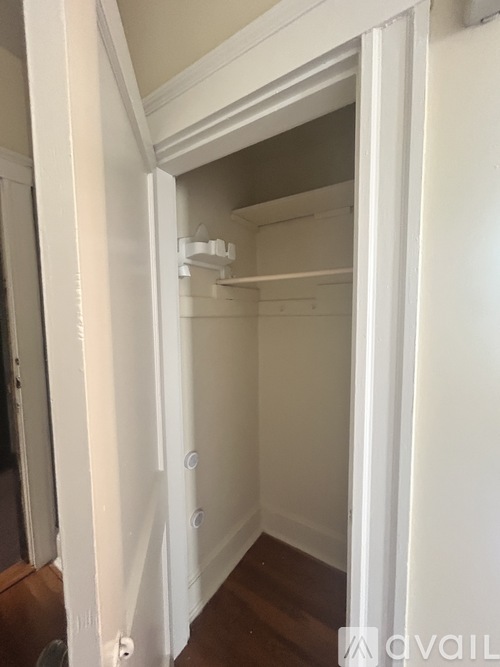 A white closet with shelves and a door open.