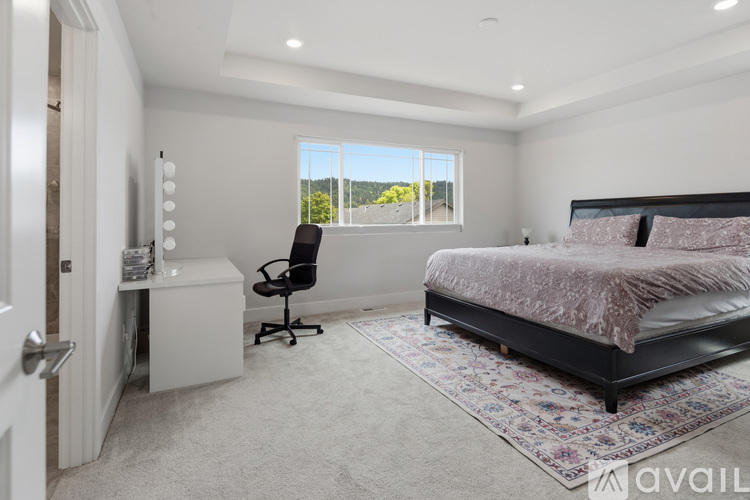 A bedroom with a bed, desk, and chair.