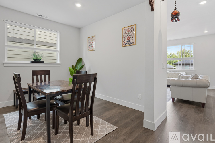 A dining room with a table and chairs.