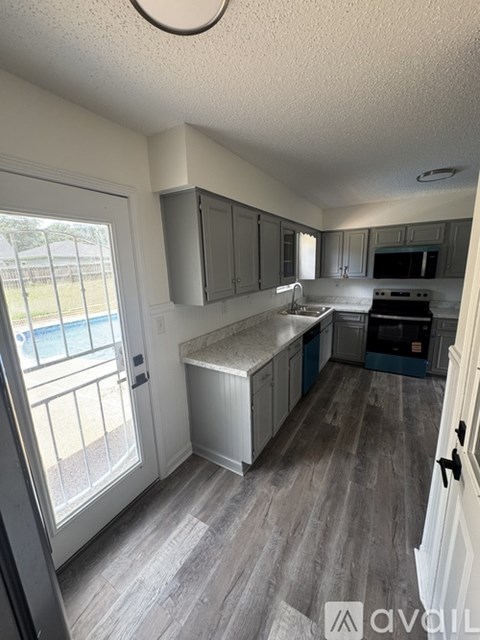 A kitchen with a white ceiling and grey cabinets.