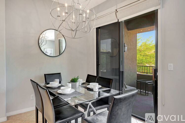 A modern dining room with a glass table and chairs.