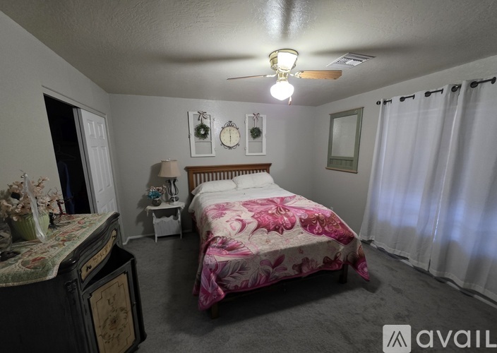 A bedroom with a bed, nightstand, and a dresser with a lamp on it.