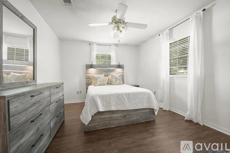 A bedroom with a bed, dresser, and mirror.
