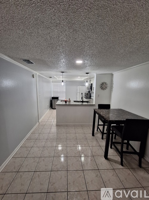 A kitchen with a table and chairs in the middle of the room.