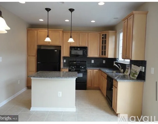 A kitchen with black appliances and wooden cabinets.