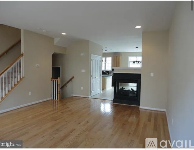 A spacious living room with a fireplace and a staircase.