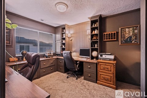 A brown office room with two chairs and a desk.