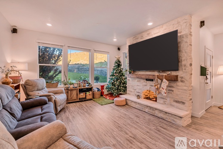 A living room with a fireplace and a television mounted above it.