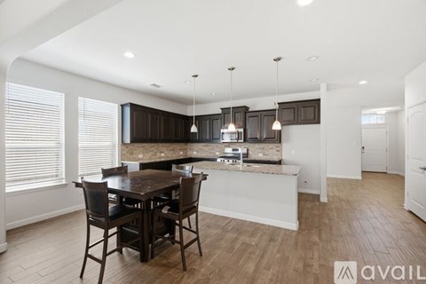 A kitchen with a table and chairs in the middle of the room.