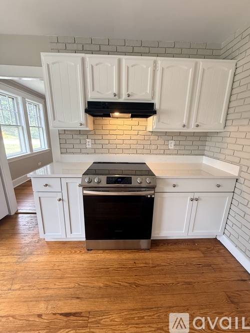 A kitchen with white cabinets and a black stove top oven.