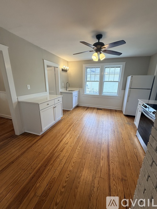A kitchen with wooden floors and white appliances.