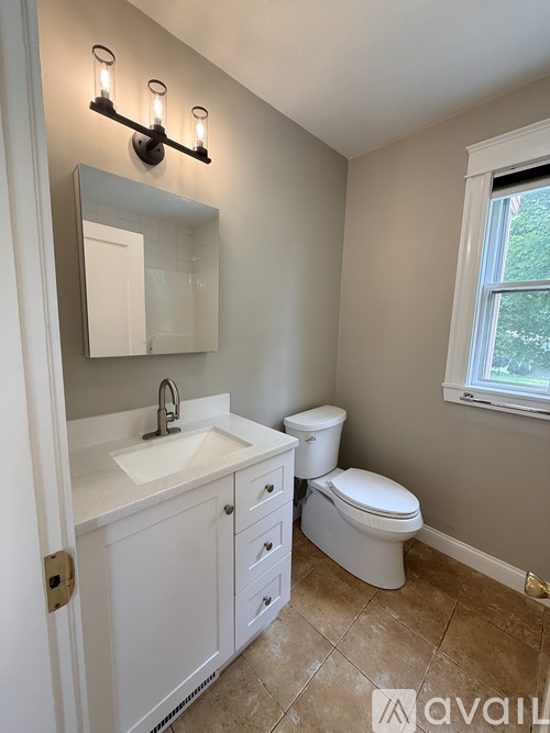 A bathroom with a sink, toilet and mirror.