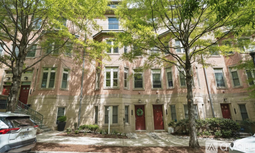 A building with red doors and windows is surrounded by trees.