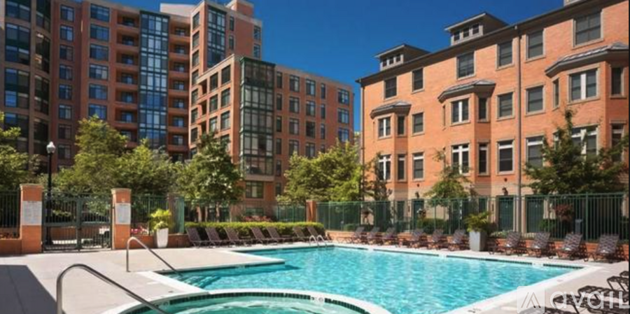 A pool surrounded by buildings and trees.