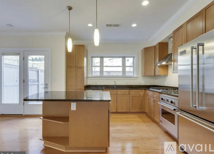A kitchen with wooden cabinets and a black countertop.