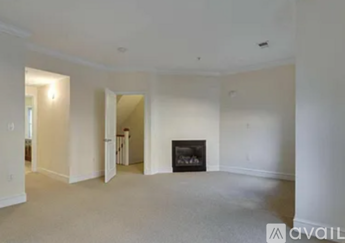 A living room with a fireplace and a doorway leading to another room.