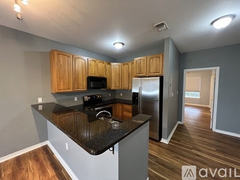 A kitchen with wooden cabinets and a black countertop.