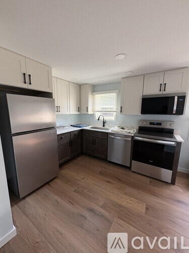 A kitchen with a refrigerator, oven, and microwave.