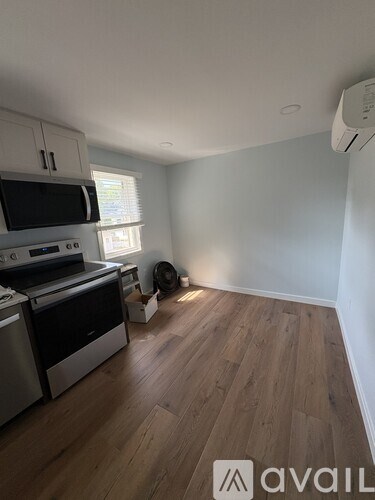 A kitchen with wooden floors and a stainless steel dishwasher and oven.