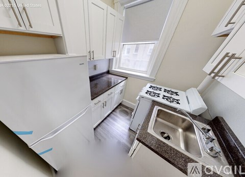 A kitchen with white cabinets and a white refrigerator.