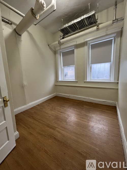 A room with wooden flooring and a white door.