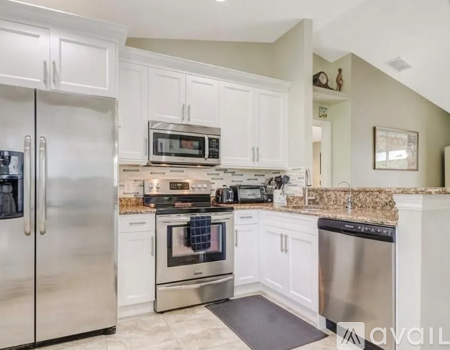 A kitchen with white cabinets and stainless steel appliances.