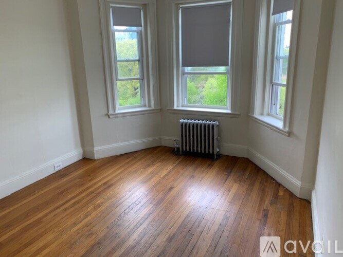 A room with wooden floors and two windows.