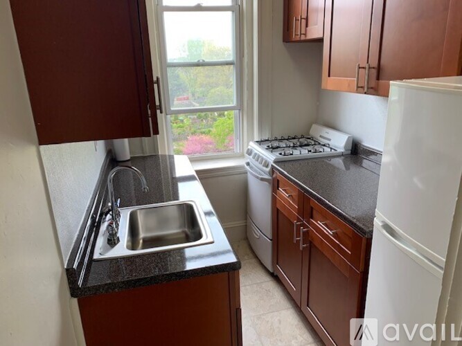 A kitchen with brown cabinets and a white fridge.