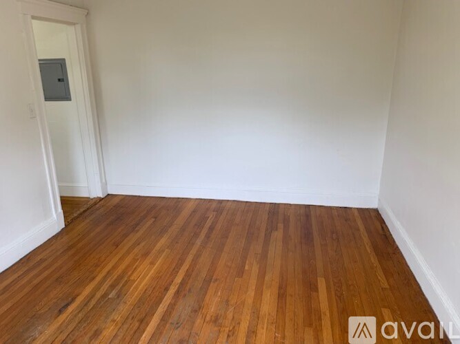 A room with wooden flooring and a white door.