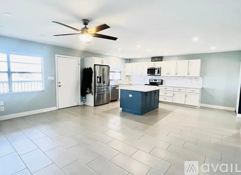 A kitchen with a blue island in the middle of the room.