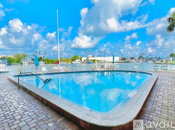 A large outdoor swimming pool surrounded by a brick patio.