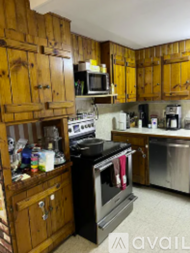 A kitchen with wooden cabinets and a black stove top oven.