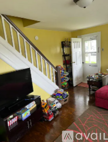 A living room with a television and toys on the floor.