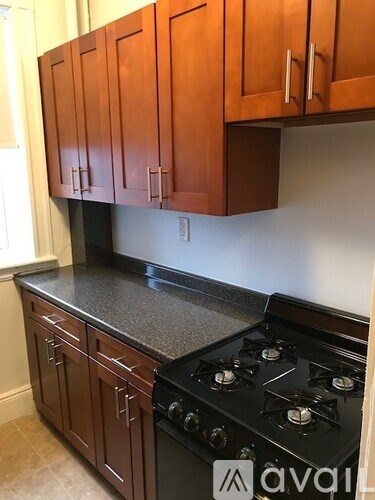 A kitchen with wooden cabinets and a black stove top.