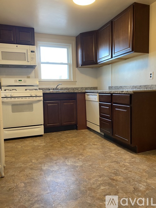 A kitchen with brown cabinets and a white stove top oven.