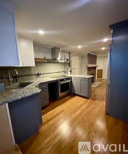 A kitchen with wooden floors and a granite counter top.