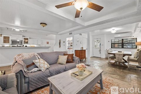 A living room with a grey couch and a wooden coffee table.