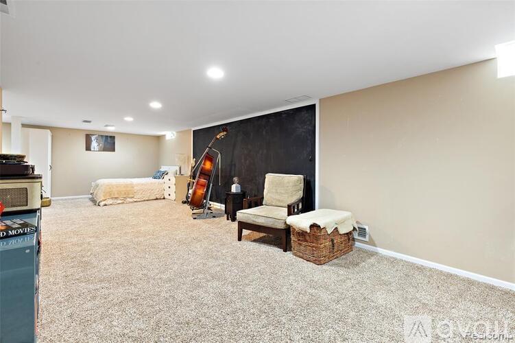 A living room with a couch, chairs, and a television.