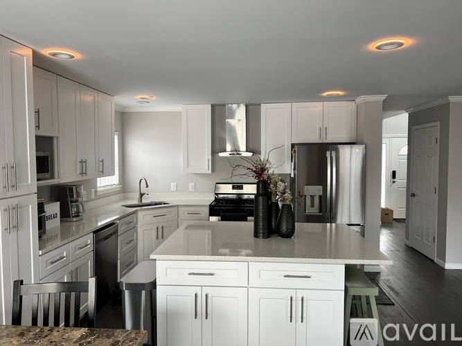 A modern kitchen with white cabinets and appliances.