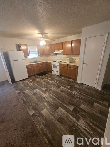 A kitchen with a white refrigerator and wooden cabinets.