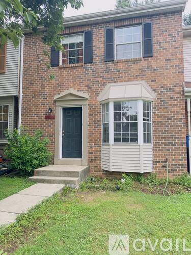 A brick house with a black door and a window with white shutters.